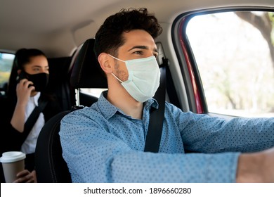 Taxi Driver With Passenger At Back Seat.