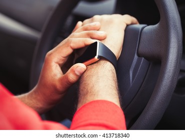 Taxi driver use map navigation app on smart watches device.Black man uses navigation application on smartwatch gadget while driving car.Driver man using smart watches mobile application on touchscreen