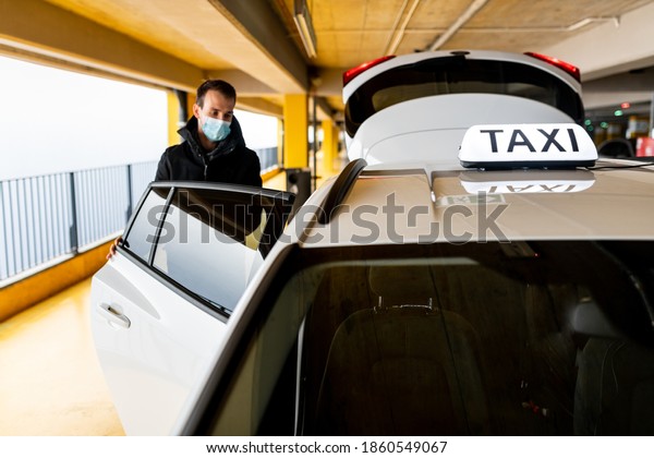 Taxi passenger getting in to the cab\
at the underground parking during coronavirus\
pandemic
