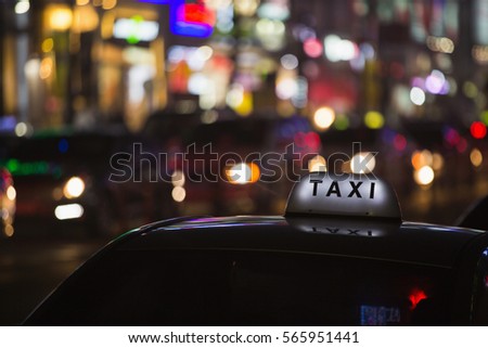 Taxi roof on a background of neon signs night city.