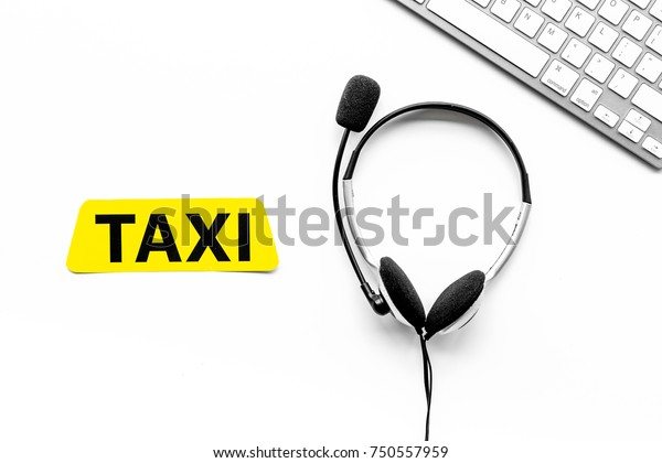 Taxi service online. Taxi label,\
keyboard, headphones on white background top\
view