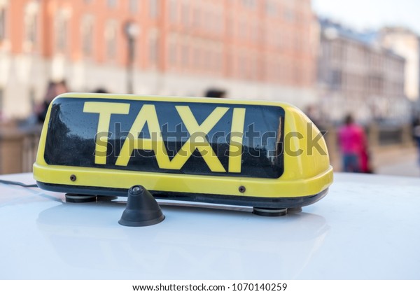 Taxi text\
on black background sign on taxi cab roof\
