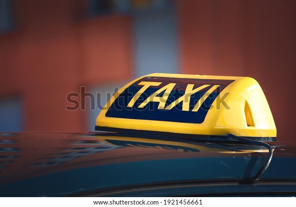 Taxi top sign.\
Taxi car sign at day time, taxi sign on cab roof while parking on\
road waiting for\
passaenger