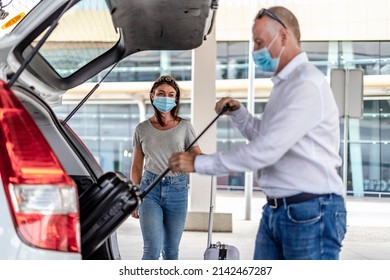 A Taxi Or Uber Driver Helping A Passenger With Her Luggage At The Airport