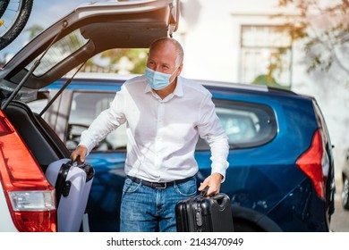 A Taxi Or Uber Driver Unloading The Luggage From The Trunk Of His Car 