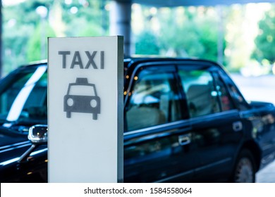 Taxi is waiting for customer behind a taxi stand sign in the front of a hotel, Tokyo, Japan - Powered by Shutterstock