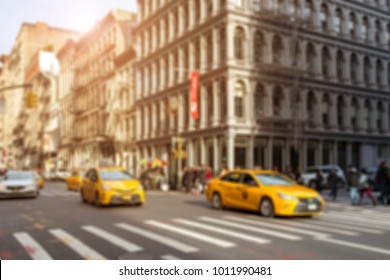 Taxis Driving Through Intersection On Broadway With Crowds Of People Shopping In The Soho Neighborhood Of New York City