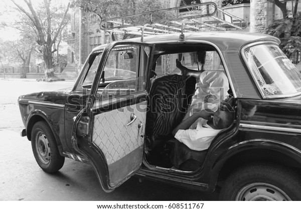 Taxy driver off duty sleeping in the car in New\
Delhi, India