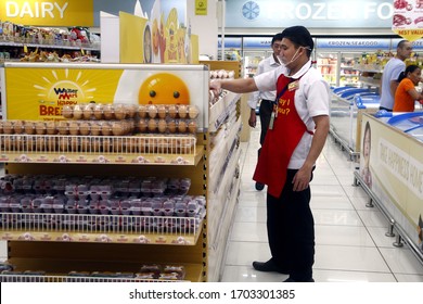 Taytay, Rizal, Philippines - March 11, 2020: Employees of a supermarket arrange stocks on shelves and counters.