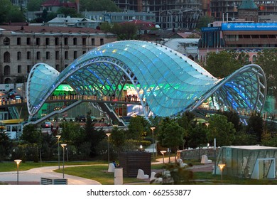 TBILISI, GEORGIA - APRIL 30, 2017: Pedestrian Peace Bridge and Rike riverside park, central landmarkds of the city center in early evening.