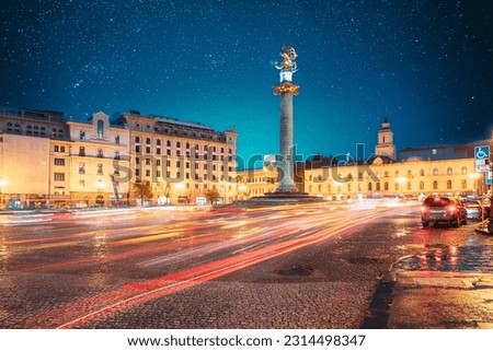 Tbilisi, Georgia, Eurasia. Amazing Bold Bright Blue Starry Sky Gradient Above Liberty Monument Depicting St George Slaying The Dragon And Tbilisi City Hall In Freedom Square In City Center. Travel.