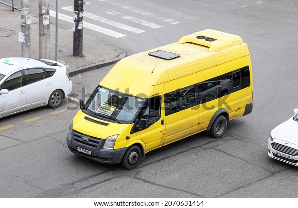 Tbilisi, Georgia - October 9, 2021: Yellow\
urban minibus Ford Transit in a city\
street.