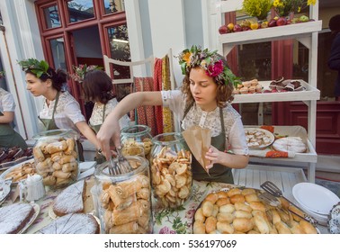 TBILISI, GEORGIA - SEP 25: Beautiful Young Girl With Flowers In Hair Selling Cookies, Cakes Of A Backery During A Street Festival On September 25, 2016. Tbilisi Has Population Of 1.5 Million People