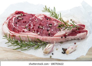 T-bone steak  with pepper, garlic and rosemary over a white background