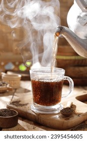 Tea is an aromatic beverage prepared by pouring hot or boiling water over cured or fresh leaves of Camellia sinensis, an evergreen shrub native to East Asia which probably originated in the borderland - Shutterstock ID 2395454605