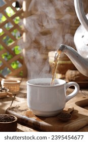 Tea is an aromatic beverage prepared by pouring hot or boiling water over cured or fresh leaves of Camellia sinensis, an evergreen shrub native to East Asia which probably originated in the borderland - Shutterstock ID 2395454677