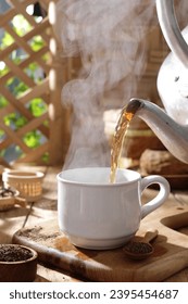 Tea is an aromatic beverage prepared by pouring hot or boiling water over cured or fresh leaves of Camellia sinensis, an evergreen shrub native to East Asia which probably originated in the borderland - Shutterstock ID 2395454687