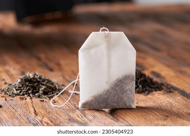 Tea bag, green and black tea on an old wooden table.