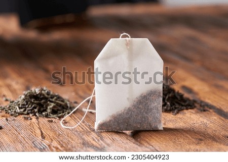 Tea bag, green and black tea on an old wooden table.