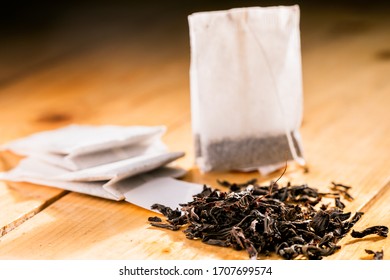 Tea bag on wooden background. Tea bag and tea leaves on a wooden background. 