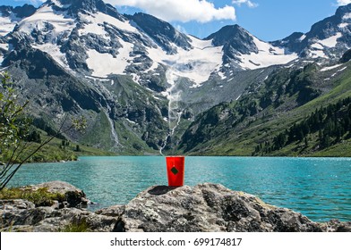 Tea Bag In Orange Plastic Cup On The Background Of The Beautiful Landscape And Blue Lakes. Tourist Hiking Romance. Breakfast In The Nature.