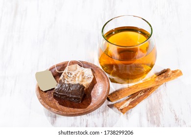 Tea and bark of cat's claw plant on wooden background, uncaria tomentosa