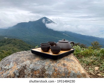 A Tea Ceremony Against A Backdrop Of Cloudy Mountains. The Way Of Spending Time With Friends In Nature Over Deep Conversation