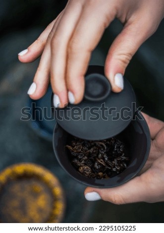 Tea ceremony in mountains, Oolong tea in a beautiful landscape, Girl hand holding blue cup with tea. A tea ceremony at rocks. The way of spending time with friends in nature.