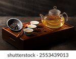 Tea ceremony on dark background. Tea pot and cup with  drink. 