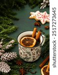 Tea with cinnamon and dried orange slices on a green winter background, Merry Christmas