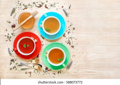 Tea Collection Of Three Different Types Of Tea - Mint, Hibiscus And Herbal Tea In Cups Isolated On Light Wooden Background. Horizontal. View From Above.