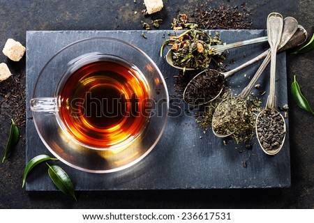 Tea composition with old spoon on dark background