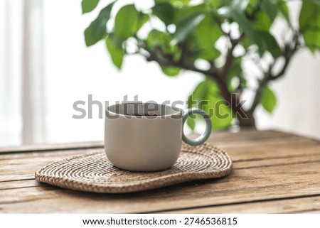 Tea cup by the window with soft green bokeh background. Calm morning.