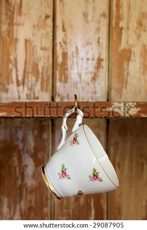 tea cup hanging on a hook in old wooden cupboard, shallow DOF