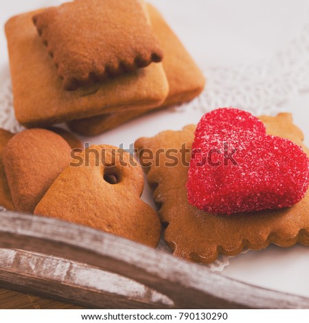 tea cup with heart shaped biscuits. Sugar red biscuits. A square, equal sides. Instaphoto with filters