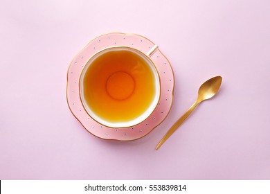 Tea cup on pastel pink background. Top view