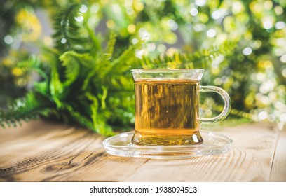 Tea Cup On Wooden Table In Front Of Floral Spring Garden Nature Outdoor With Bokeh Light. Front View