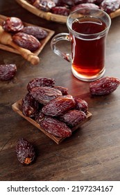 Tea and dried dates on a old wooden table.