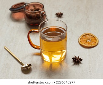 Tea in glass cup on table with dried orange, anise and spoon, tea time concept - Powered by Shutterstock