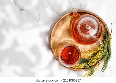 Tea in Glass Cup and glass teapot on wooden tray with mimosa. Sunny light. Copy space - Powered by Shutterstock