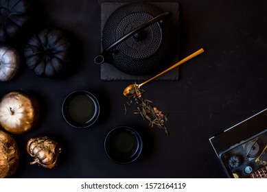 
Tea In A Jug. Black Cups, A Golden Teaspoon. Japanese Tradition. Black Background. View From Above.