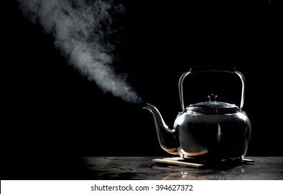 Tea Kettle With Boiling Water On A Black Background