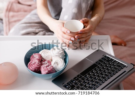 Tea, laptop and sweets at morning. Social network, remote work, leisure concept