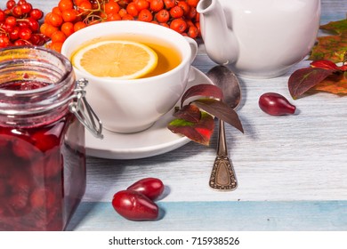 tea with lemon and cherry jam in a jar on a rustic wooden table pines leaves