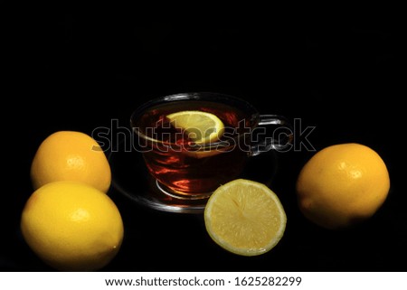 Tea, lemon, yellow, hot vitamin drink on a dark background, invigorating morning retro setting, rest time.