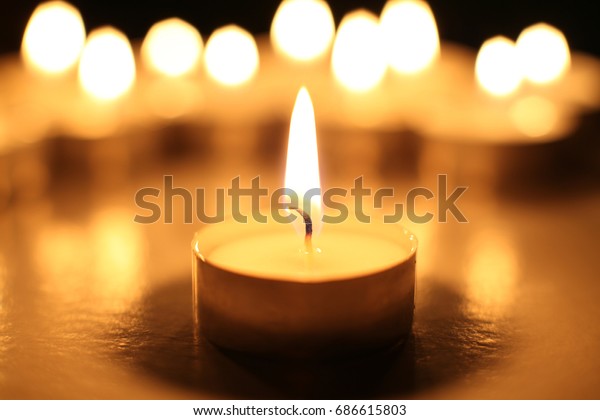 tea light or candle against blurred group of\
candle lights