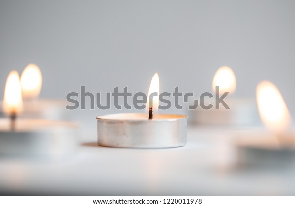Tea
light candles lit with flame on a white
background
