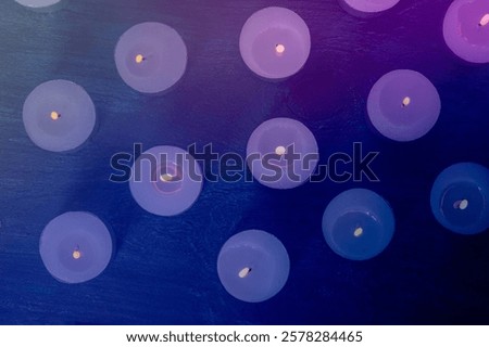 Tea light candles on a dark background, many lights in the dark, candlelight, toned image