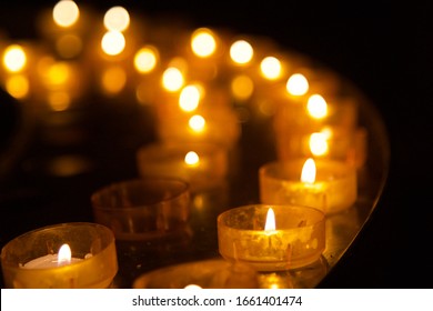 Tea light Votive prayer candles lit up in church in remembrance of loved ones or vigil. Tealight votive candles lit up for ambience or yoga or meditation. - Powered by Shutterstock