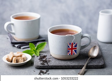 Tea In Mugs With British Flag Tea Bag Label. Grey Background. Close Up.